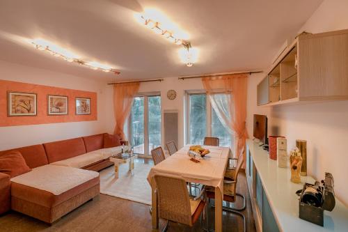 ein Wohnzimmer mit einem Tisch und einem Sofa in der Unterkunft Palm Point Apartment in Petrovac na Moru