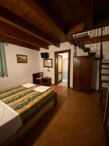 a bedroom with a bed and a spiral staircase at La Cascina per un Sogno in Tornimparte