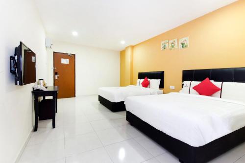 a hotel room with two beds and a television at Central Hotel in Bahau