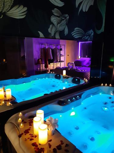 une baignoire jacuzzi dans une chambre d'hôtel avec bougies dans l'établissement Suite Calypso, à Agde