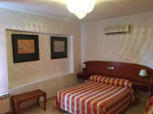 a bedroom with a bed and two pictures on the wall at Gran Hostal Asador de Soto in Soto Real