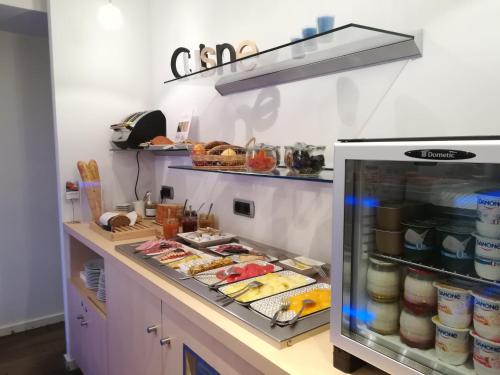 a kitchen with a counter with food in a refrigerator at Hôtel Mercure Vittel in Vittel
