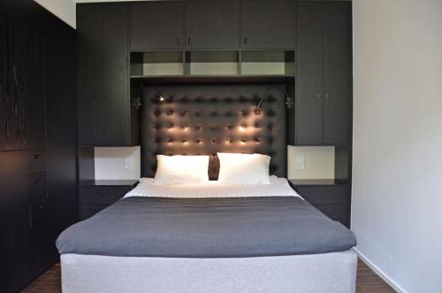 a bedroom with a large bed with black cabinets at Forenom Serviced Apartments Göteborg Geijersgatan in Gothenburg