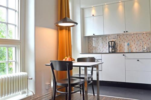 a kitchen with a table and chairs in a room at Forenom Serviced Apartments Göteborg Geijersgatan in Gothenburg