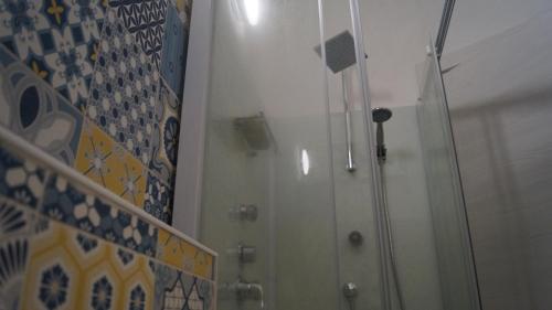 a shower in a bathroom with a glass door at Domo 'e chelu in Orosei