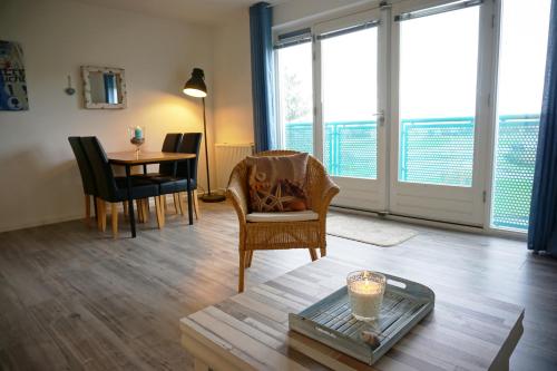 a living room with a table and chairs and windows at Strandslag Juliana 135 in Julianadorp