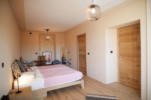 a bedroom with a bed with a pink blanket at Casa ViniToscani in Perroy