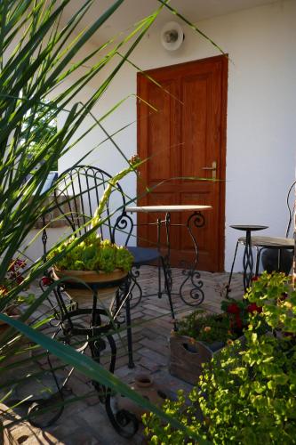 a patio with a table and chairs and plants at House of LoVra in Kneževi Vinogradi