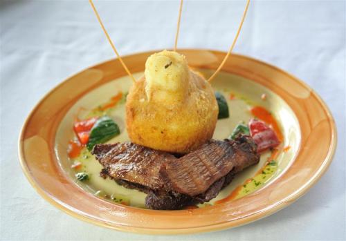 a plate of food with meat and a pastry on it at Mara River Lodge in Aitong