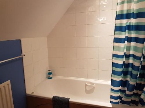 a bathroom with a bath tub with a shower curtain at Ivy Farm Accommodation in Newark-on-Trent