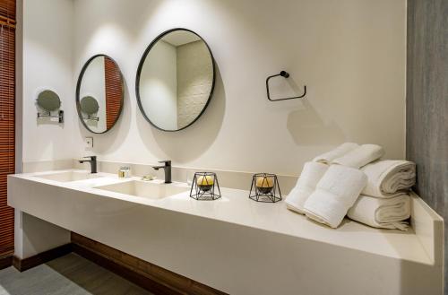 a bathroom with a sink and two mirrors at Alko Hotel Casa Nispero in Cali