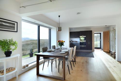 a dining room and kitchen with a table and chairs at Skye Lair in Teangue