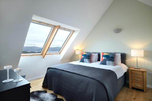 1 dormitorio con 1 cama extragrande y ventana en Skye Lair, en Teangue