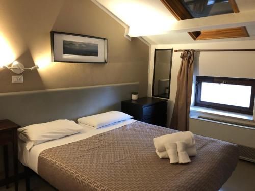 sypialnia z łóżkiem z białymi ręcznikami w obiekcie Hotel Casale dei Massimi w Rzymie