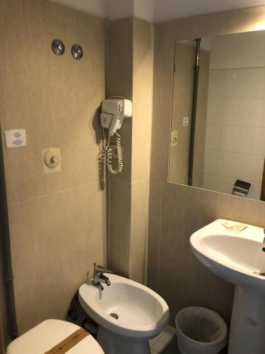 a bathroom with a sink and a phone on the wall at Hotel Casale dei Massimi in Rome