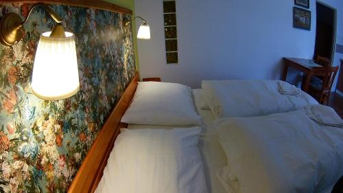 a room with two beds and a light on the wall at Penzion Slunečno in Dobšín
