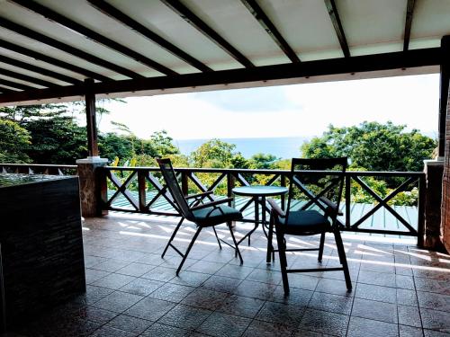 a table and chairs sitting on a balcony with a view at Rose Self Catering in Beau Vallon