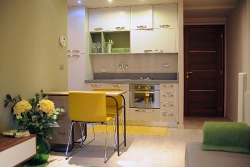 a kitchen with a table and some yellow chairs at Street View in La Morra