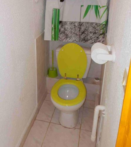 La salle de bains est pourvue de toilettes jaunes. dans l'établissement studio naturiste, au Cap d'Agde