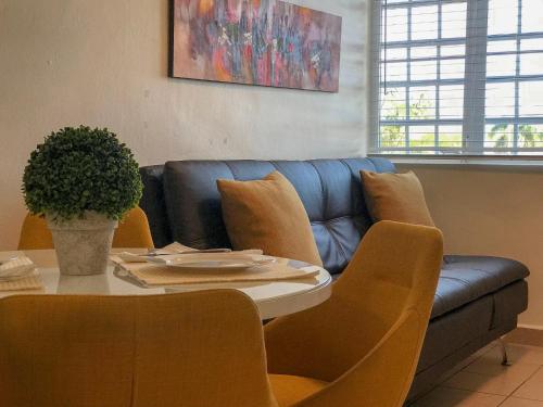 a living room with a table and a blue couch at Private Jacuzzi Oasis with Mountain Views and FREE Parking in Ponce