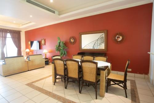 a dining room with red walls and a table and chairs at Lafontaine Rose Beach Resort in Durat Alarous
