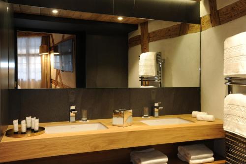 a bathroom with two sinks and a large mirror at 5 Terres Hotel & Spa - MGallery Collection in Barr