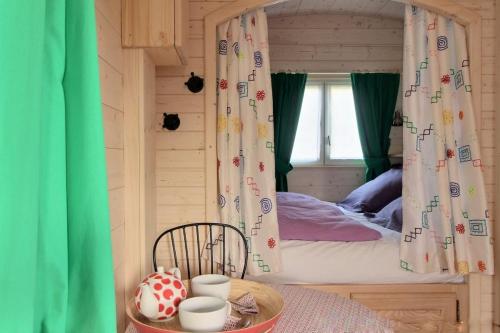 a small bedroom with a bed with a window at LE PETIT NID DANS LA ROULOTTE in Roscanvel