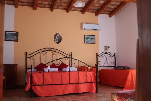 una camera con due letti con lenzuola rosse di Baglio Cracchiolo Casa Baldo a San Vito lo Capo