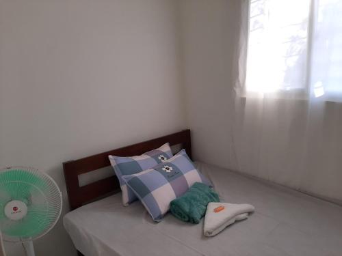 a bedroom with a bed with pillows and a fan at Kalinaw Stay and Café in El Nido