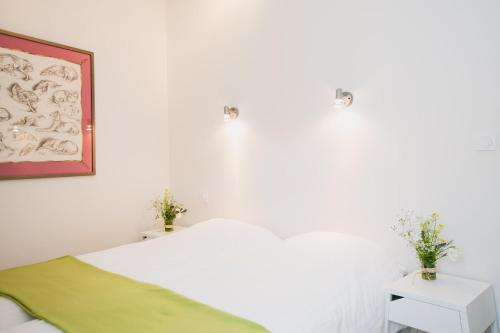 une chambre blanche avec un lit et deux tables de nuit dans l'établissement Regina's Banyuls Terrace apartment, à Banyuls-sur-Mer