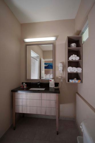 a bathroom with a vanity with a mirror and a sink at Punta Borinquen Resort in Aguadilla