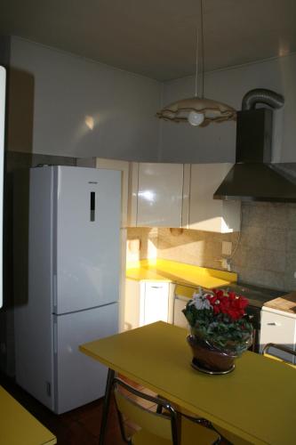 a kitchen with a table and a white refrigerator at Stop and Go in Olgiate Comasco