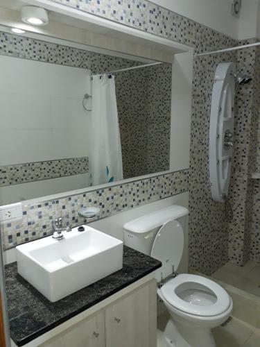 a bathroom with a sink and a toilet and a mirror at Departamentos37Depto2 in Santa Teresita
