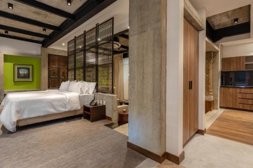 a bedroom with a large bed and green walls at Alko Hotel Casa Nispero in Cali