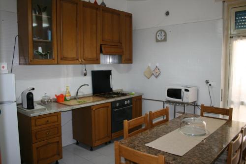 ペスカーラにあるAdriaticaのキッチン(木製キャビネット、テーブル、椅子付)