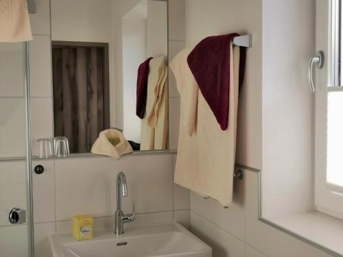 a bathroom with a sink and a mirror and towels at Hotel Mauernböck in Rottenbach