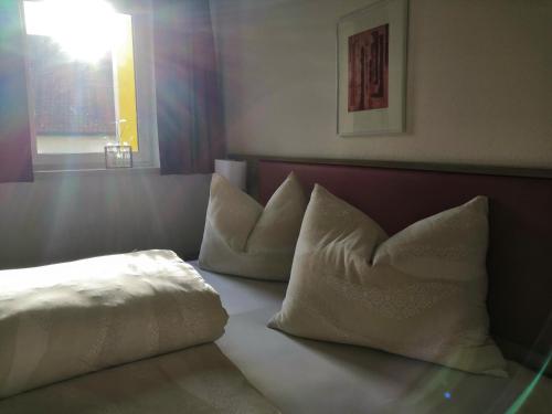 a bed with two pillows sitting on top of it at Hotel Mauernböck in Rottenbach