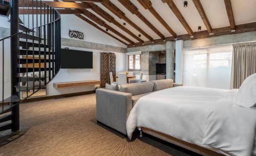 a bedroom with a large bed and a living room at Alko Hotel Casa Nispero in Cali