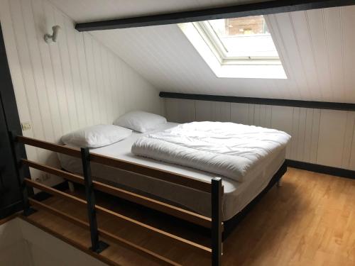 uma cama num quarto com uma clarabóia em Villa Coquelicot Plage em Le Tréport