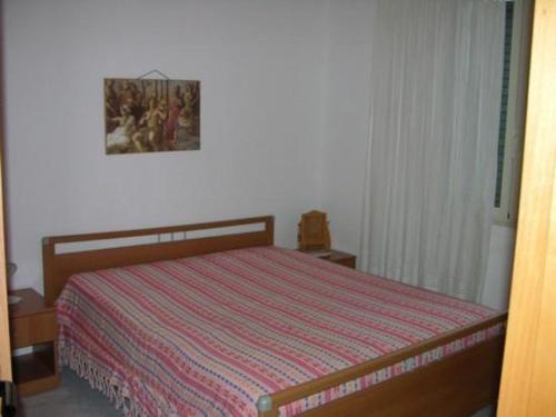 a bedroom with a bed with a striped bedspread at Villeta Laura in Baia verde in Il Monte