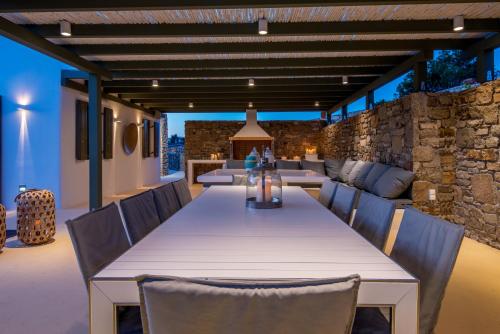 een buiteneetkamer met een tafel en stoelen bij Margi Villas in Mykonos-stad