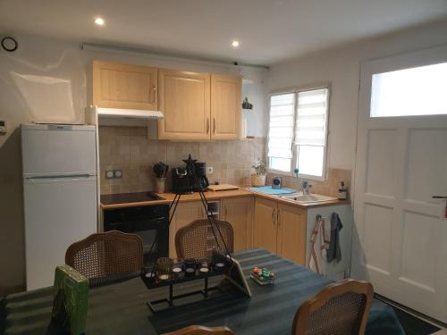 une cuisine avec une table et un réfrigérateur blanc dans l'établissement Le Jacobin, à Troyes