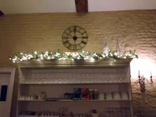 a fireplace mantle with christmas lights and a clock at Auberge 's Gravenhof in Voeren