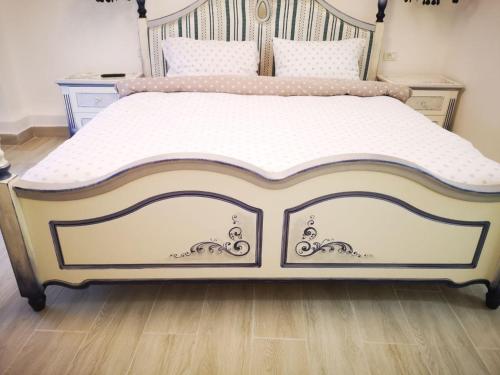 Una cama con marco blanco y dorado. en Stay in TimisoarAcom, en Timisoara