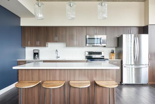 uma cozinha com armários de madeira e um balcão branco em Sonder at McKinley em Phoenix