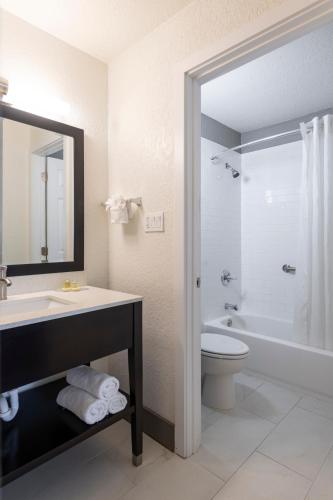 a bathroom with a sink and a toilet and a mirror at Hotel Monreale Express International Drive Orlando in Orlando