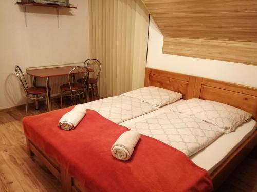1 Schlafzimmer mit 2 Betten, einem Tisch und einem Tisch in der Unterkunft Guest House Kovalik in Suchá Hora