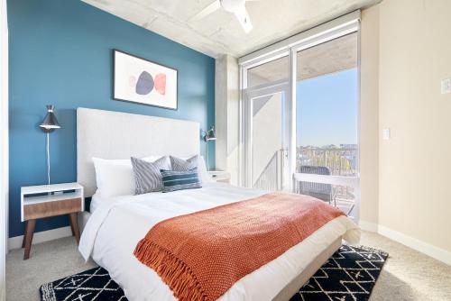 1 dormitorio con 1 cama grande y paredes azules en Sonder at McKinley en Phoenix