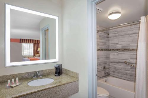 a bathroom with a sink and a toilet and a tub at Howard Johnson by Wyndham Vero Beach/I-95 in Vero Beach