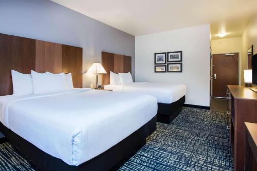 a hotel room with two beds and a television at La Quinta by Wyndham Morgantown in Morgantown